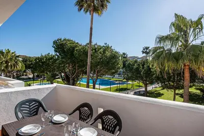 a table and chairs on a balcony with a view of a pool at carrajolilla 7B 13 in Chiclana de la Frontera