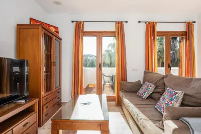 a living room with a couch and a tv at carrajolilla 7B 13 in Chiclana de la Frontera