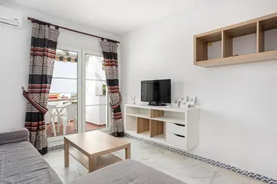a living room with a couch and a tv at Laja Bermeja in Chiclana de la Frontera