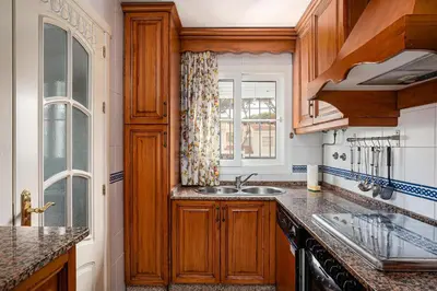 a kitchen with wooden cabinets and a sink at Laja Bermeja in Chiclana de la Frontera