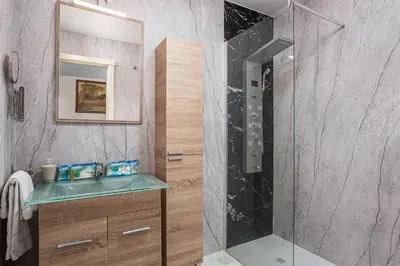 a bathroom with a glass shower and a sink at Laja Bermeja in Chiclana de la Frontera