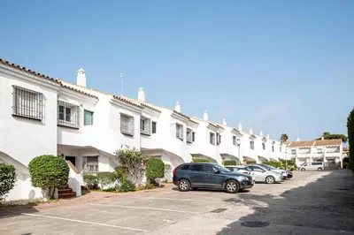 a row of buildings with cars parked in a parking lot at Laja Bermeja in Chiclana de la Frontera