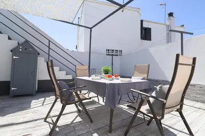 a table and chairs on a rooftop patio at Casa Nao Santiago - Sanlúcar de Barrameda - Centro Playa in Sanlúcar de Barrameda