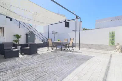 a patio with a table and chairs and a building at Casa Nao Santiago - Sanlúcar de Barrameda - Centro Playa in Sanlúcar de Barrameda