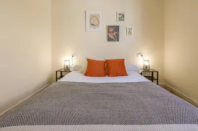 a bedroom with a bed with two orange pillows at Cadizz Entre Cielo y Mar Centro del Puerto ciudad - ideal empresas, familias y grupos in El Puerto de Santa María
