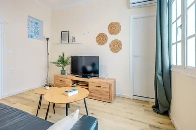 a living room with a tv and a table at Cadizz Entre Cielo y Mar Centro del Puerto ciudad - ideal empresas, familias y grupos in El Puerto de Santa María