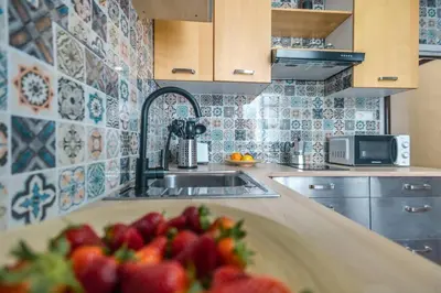 a kitchen with a sink and a bowl of strawberries at Cadizz Entre Cielo y Mar Centro del Puerto ciudad - ideal empresas, familias y grupos in El Puerto de Santa María