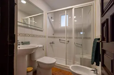 a bathroom with a shower and a toilet and a sink at Cadizz Entre Cielo y Mar Centro del Puerto ciudad - ideal empresas, familias y grupos in El Puerto de Santa María