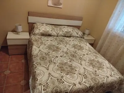 a bed in a bedroom with two night stands and two tables at Chalet Jones in Chiclana de la Frontera
