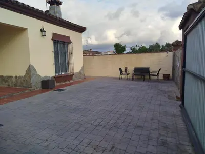 a patio with two chairs and a wall at Chalet Jones in Chiclana de la Frontera