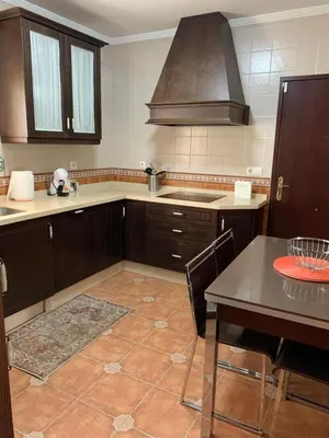 a kitchen with wooden cabinets and a table and a stove at Casa Jones in Chiclana de la Frontera