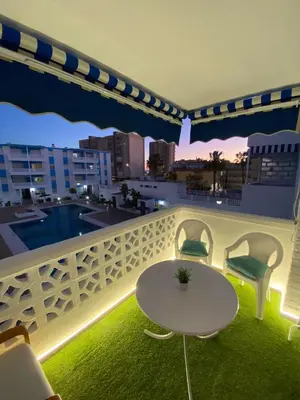 a balcony with a table and chairs and a view of a city at Apartamento Las Sirenas in Chipiona