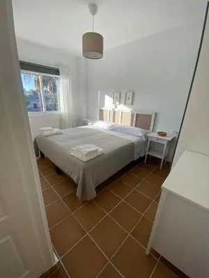 a bedroom with a bed and a tiled floor at Costa ballena en primera linea in Costa Ballena