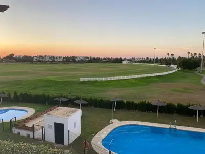 an aerial view of a golf course with two pools and umbrellas at Costa ballena en primera linea in Costa Ballena
