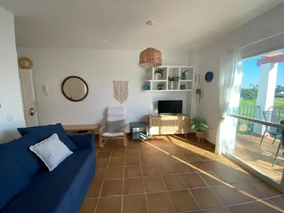 a living room with a blue couch and a table at Costa ballena en primera linea in Costa Ballena