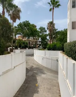 a street with a white fence and palm trees at Costa ballena en primera linea in Costa Ballena