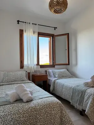 a bedroom with two beds and a window at BARROSA CON ENCANTO, AC - WIFI - PARKING, Parejas y familias in Novo Sancti Petri