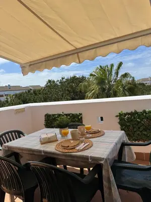 a table with two glasses of orange juice on a patio at BARROSA CON ENCANTO, AC - WIFI - PARKING, Parejas y familias in Novo Sancti Petri