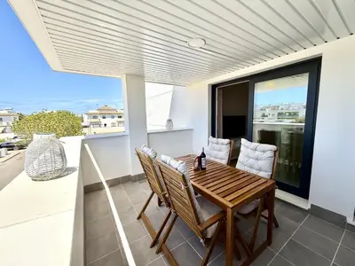 a dining room with a table and chairs on a balcony at El rincon de candor by staycare in Rota