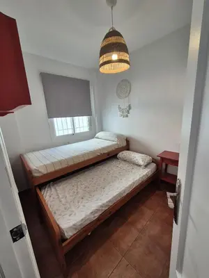 a bedroom with two beds and a pendant light at El Patio Grande in Sanlúcar de Barrameda