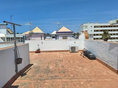 a rooftop with a brick floor and a wall at El Patio Grande in Sanlúcar de Barrameda