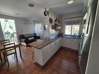a kitchen and living room with a table and a couch at El Patio Grande in Sanlúcar de Barrameda