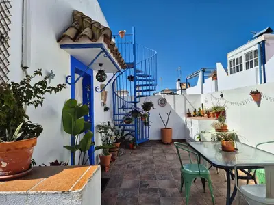 a patio with blue doors and a table and chairs at El Patio Grande in Sanlúcar de Barrameda