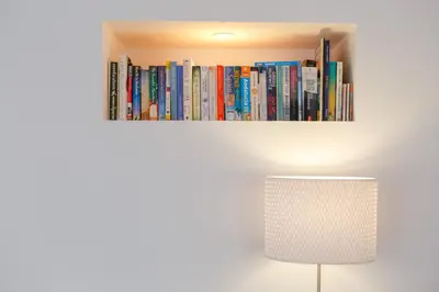 a book shelf filled with books next to a lamp at ALBA Apartment by Cadiz4Rentals in Cádiz