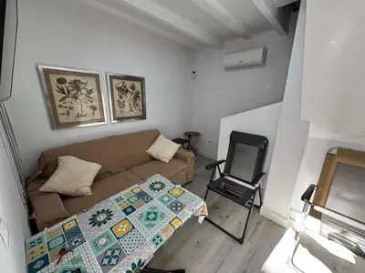 a white bedroom with a bed and a table at Apto Nº1 LAVANDA y Apto Nº 3 JAZMIN in Chipiona