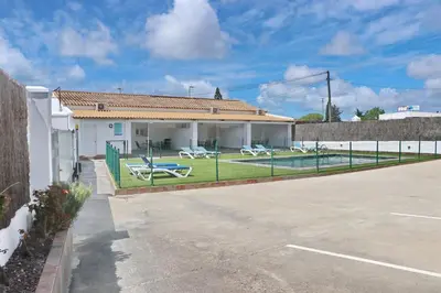 a house with a fence and a tennis court at Apartamento Canario I in Conil de la Frontera