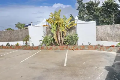 a tennis court in front of a white house at Apartamento Canario I in Conil de la Frontera