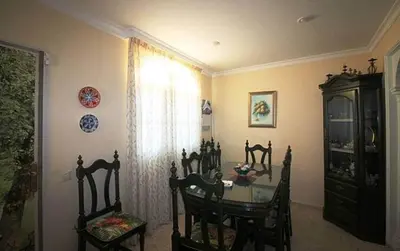 a dining room with a table and chairs and a window at Chalet junto a la playa de La Barrosa in Novo Sancti Petri