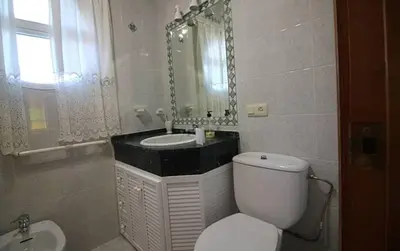 a bathroom with a toilet and a sink and a mirror at Chalet junto a la playa de La Barrosa in Novo Sancti Petri