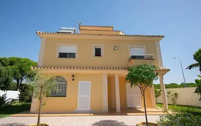 a large yellow house with at Chalet junto a la playa de La Barrosa in Novo Sancti Petri