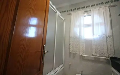 a bathroom with a window and a sink and a mirror at Chalet junto a la playa de La Barrosa in Novo Sancti Petri