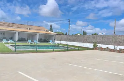 a tennis court in front of a house at Apartamento Canario II in Conil de la Frontera