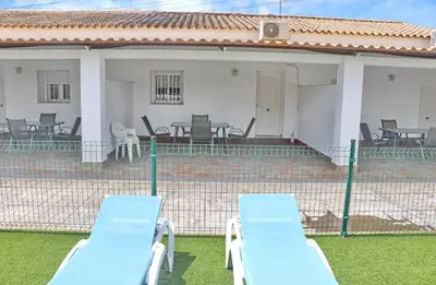 two blue lounge chairs in front of a house at Apartamento Canario II in Conil de la Frontera