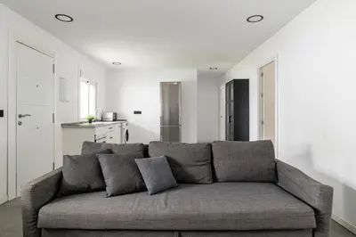 a living room with a gray couch in a room at Chiclana Dreamhouse in Chiclana de la Frontera