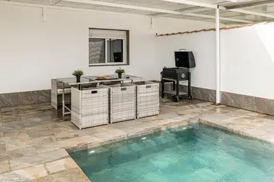 a large swimming pool in a room with a table and a television at Chiclana Dreamhouse in Chiclana de la Frontera