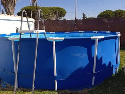 a blue boat sitting in the grass near a fence at La fuente in Novo Sancti Petri