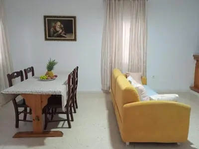a living room with a table and a yellow couch at La fuente in Novo Sancti Petri