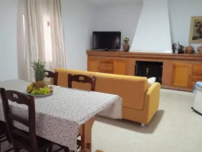a living room with a table and a yellow couch at La fuente in Novo Sancti Petri