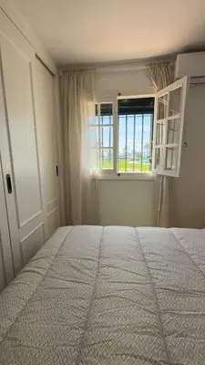 a bedroom with a large bed and a window at Frente al Mar in Novo Sancti Petri