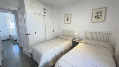 a bedroom with two beds and a table in it at Frente al Mar in Novo Sancti Petri
