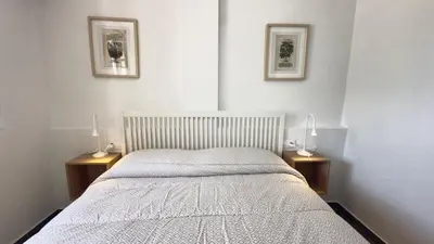 a bedroom with a bed with two lamps on two tables at Frente al Mar in Novo Sancti Petri