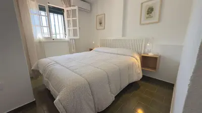 a bedroom with a bed in a room with a window at Frente al Mar in Novo Sancti Petri