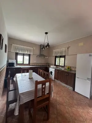 a kitchen with a table and a white refrigerator at Viangel 2 in Conil de la Frontera
