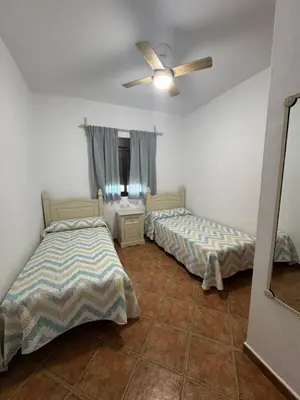 a bedroom with two beds and a ceiling fan at Viangel 2 in Conil de la Frontera