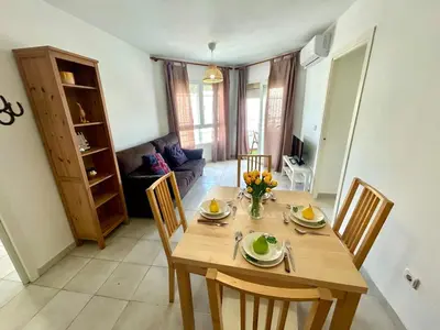 a dining room with a wooden table and chairs at GATU Magavi Playa parking piscinas terraza 