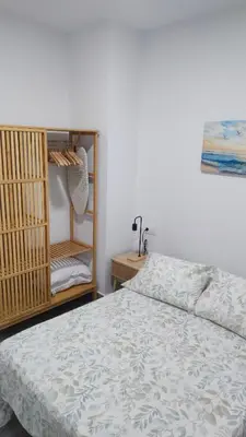 a bedroom with a bed and a book shelf at Apto G2 SANLUCAR DE BARRAMEDA in Sanlúcar de Barrameda